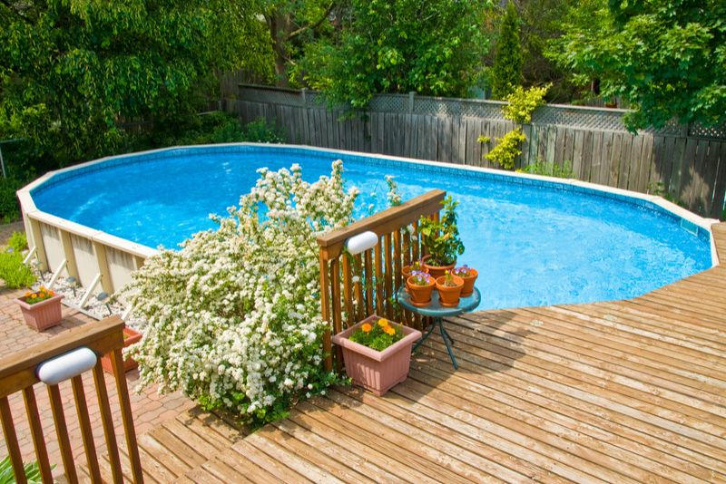 pool deck made of timber with potted plants all round